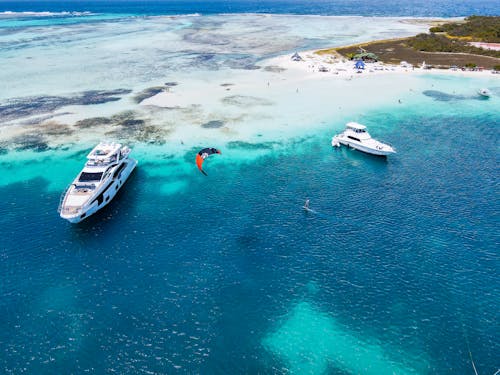 Kitesurfer between Yachts in Sea