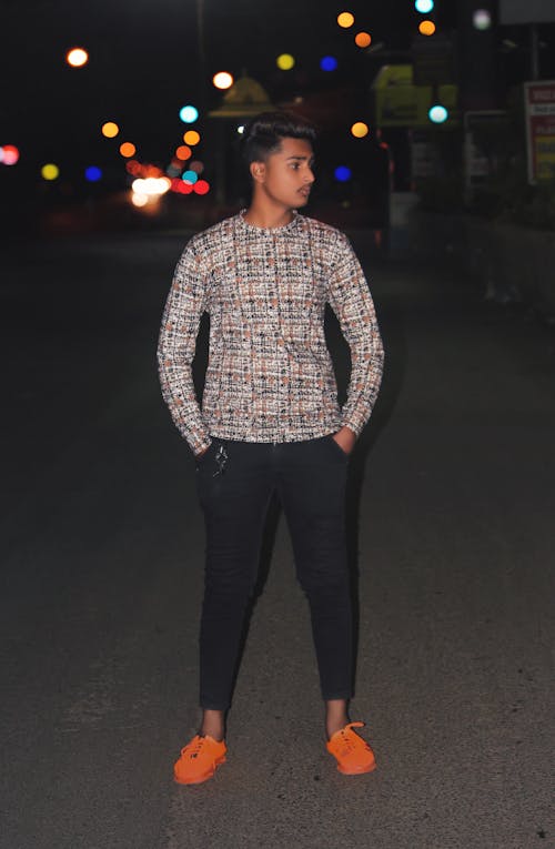 Young Man Standing On A Road With Light Bokeh Effect