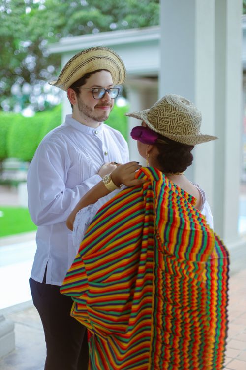 Free A young couple in traditional clothing sharing a romantic moment outdoors with vibrant colors and smiles. Stock Photo