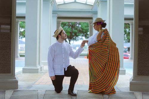 Free A man proposing to a woman in colorful cultural attire under a pavilion. Stock Photo