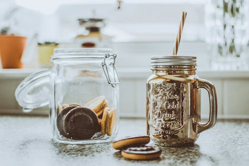 Two Clear Glass Mason Jars on Black Surface