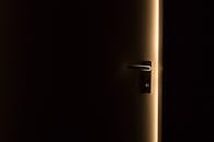 一间黑暗的房间里，门半开着，从门缝中透出一道微光