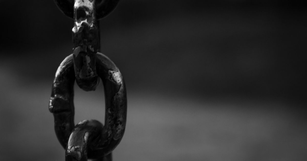 A close-up of heavy steel chain links holding firm, a picture of a streak the moment before it snaps.