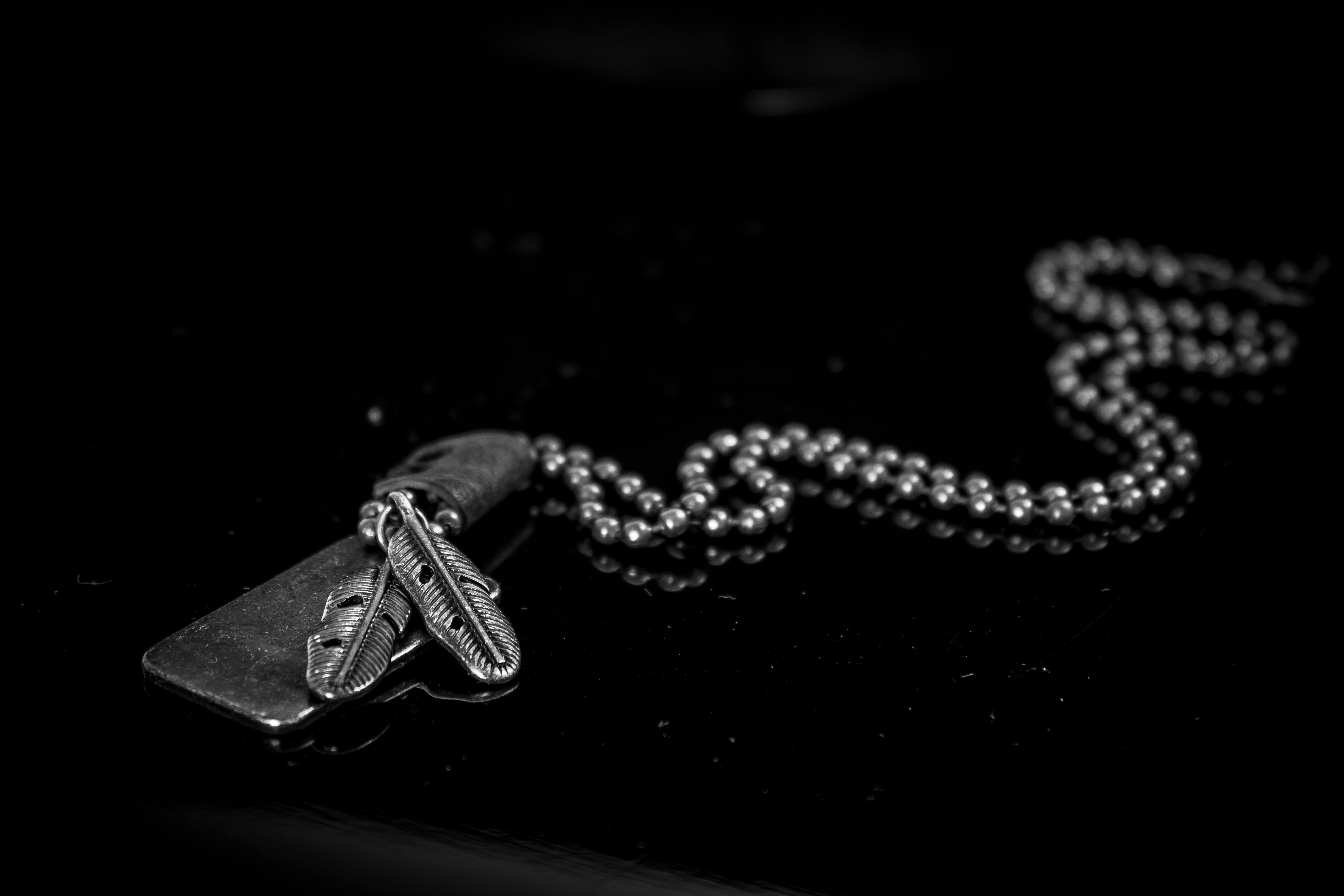 silver dog tag necklace on black background