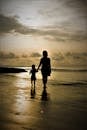 Silhouette of Mother and Child Walking on Beach
