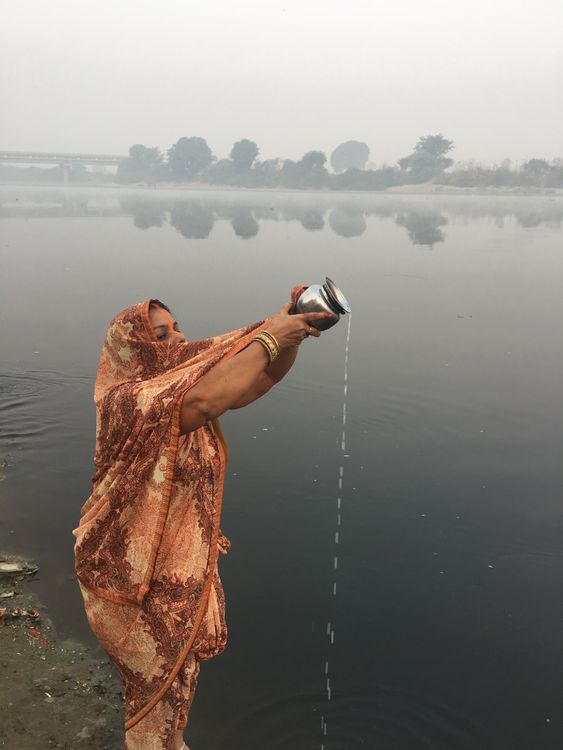 Woman Wearing Traditional Clothing Pouring Water into a River from a ...