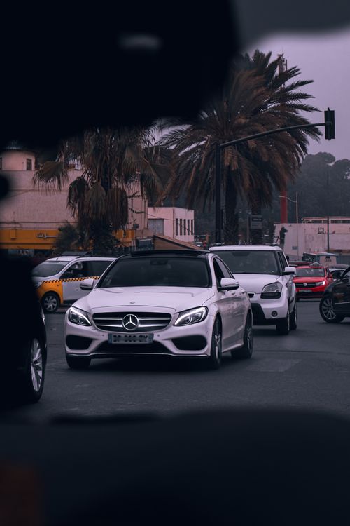 Free Street view of city traffic featuring various cars and palm trees. Stock Photo