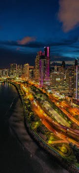 Dazzling aerial view of Panama City's illuminated skyline and waterfront at night.