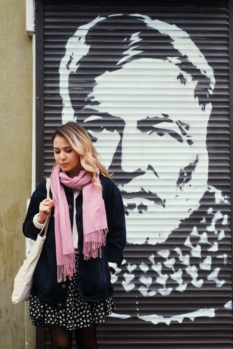 Young Woman In City In Front Of A Door With Painting 