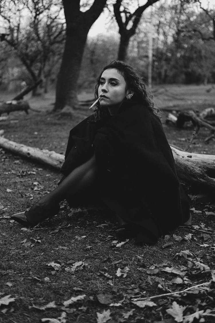 Woman Sitting On The Ground With A Cigarette 