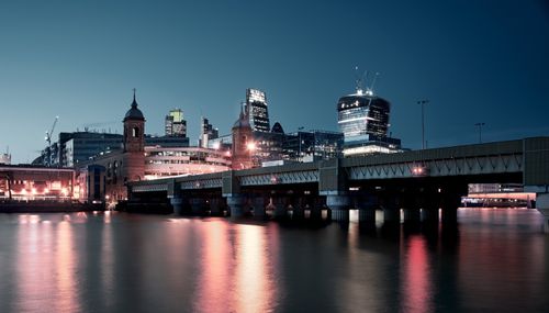 Free Nighttime cityscape of London featuring Cannon Street Railway Bridge and modern skyscrapers. Stock Photo