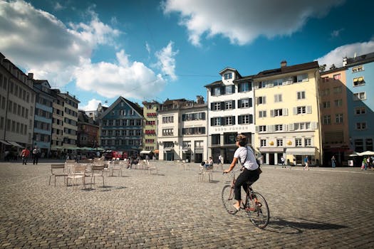 一名骑自行车的人穿过充满活力的城市广场，在明亮的天空下，周围环绕着色彩缤纷的建筑