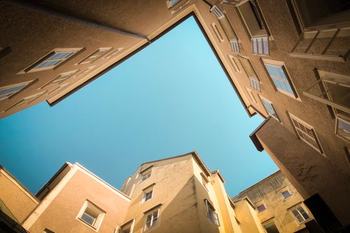 Free Low angle view of modern urban buildings against a clear blue sky, showcasing architectural design. Stock Photo