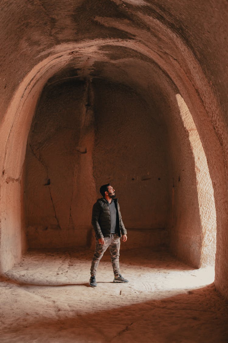 Young Man Standing In Old Cave