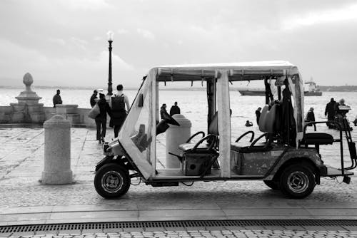 Black and White Photo of an Electric Car by a Seaside