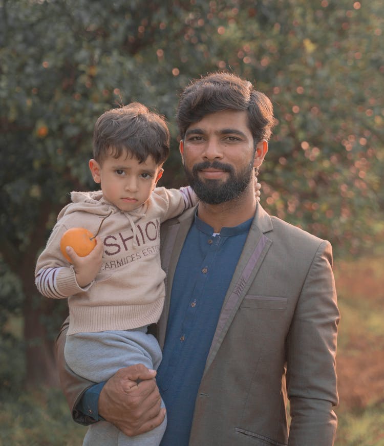 Man Holding A Child In His Arm