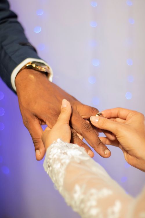 Free Close-up of a couple exchanging wedding rings at a romantic ceremony. Stock Photo