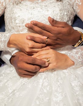 Close-up of interracial couple's hands with wedding rings symbolizing unity and love.