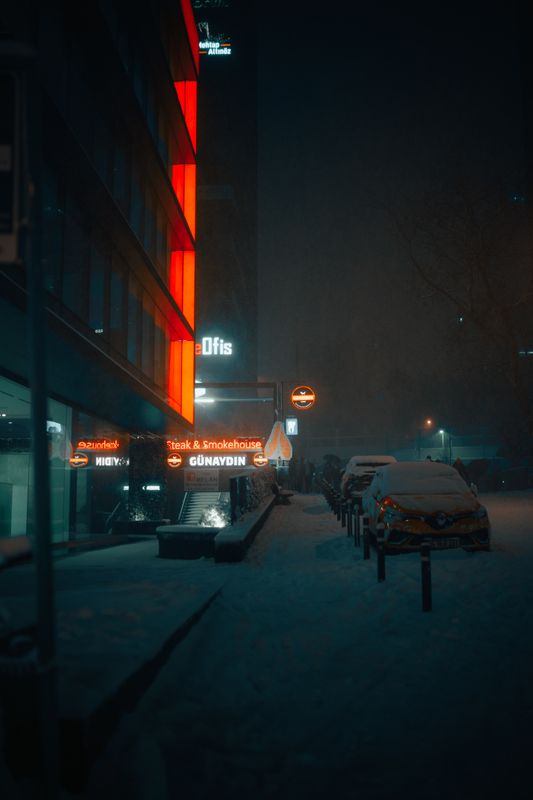 Gece neon ışıklı karlı bir sokak