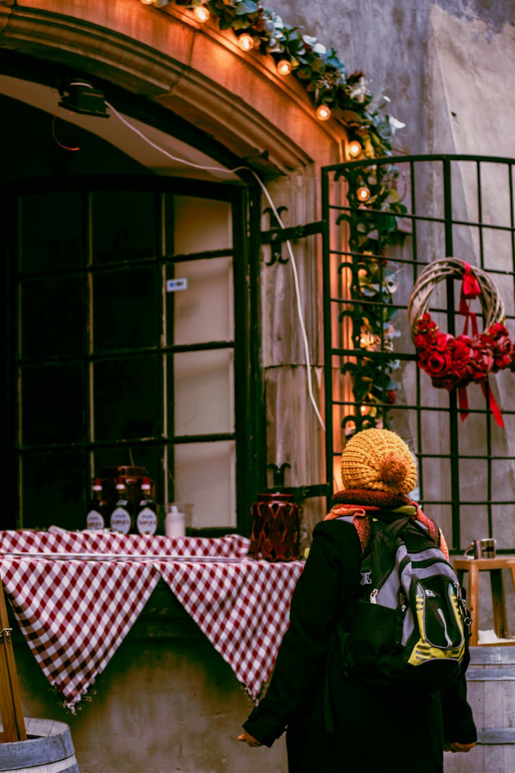 Woman Near Decorated For Christmas Cafe Window