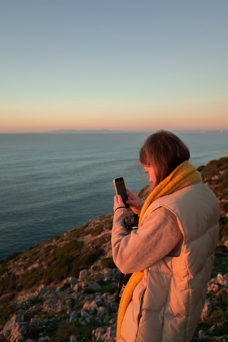 A Woman With A Smartphone At Sunset 