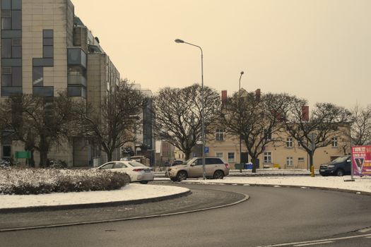 Snow-covered roundabout with buildings in Zielona Góra, Poland during winter.