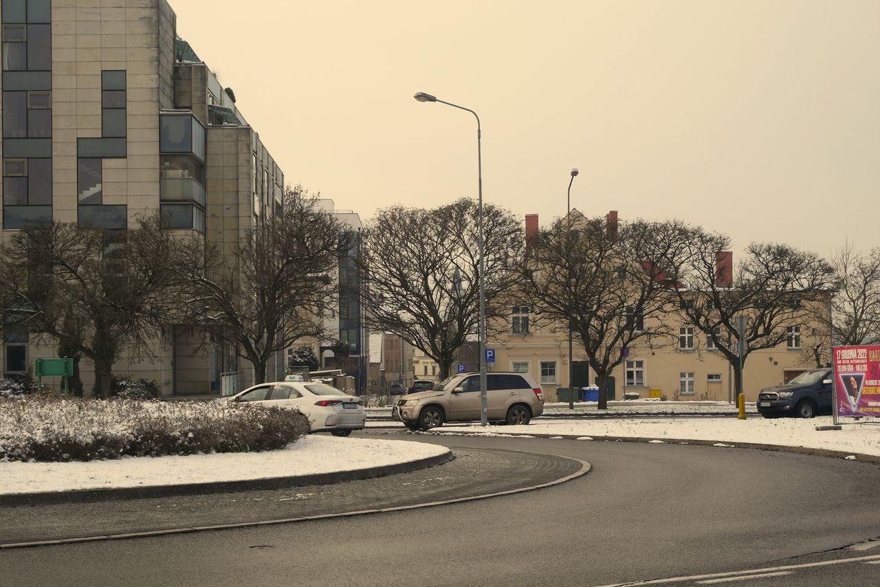 snow covered roundabout with buildings in zielona g ra poland during w