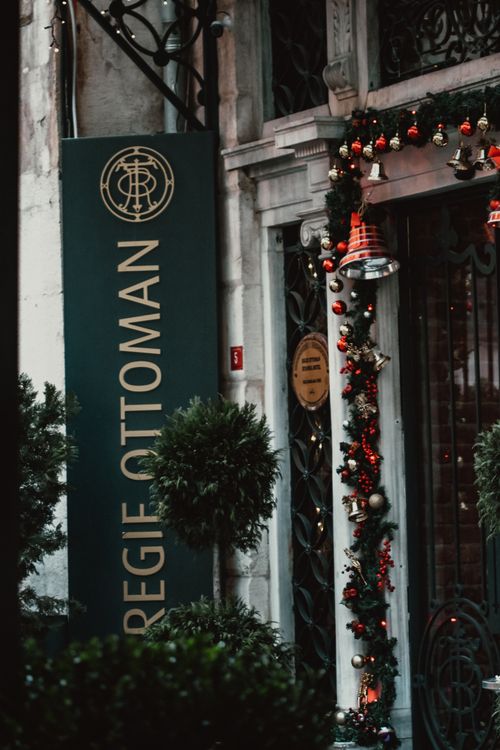 Free Elegant doorway adorned with festive Christmas decorations in a city street setting. Stock Photo
