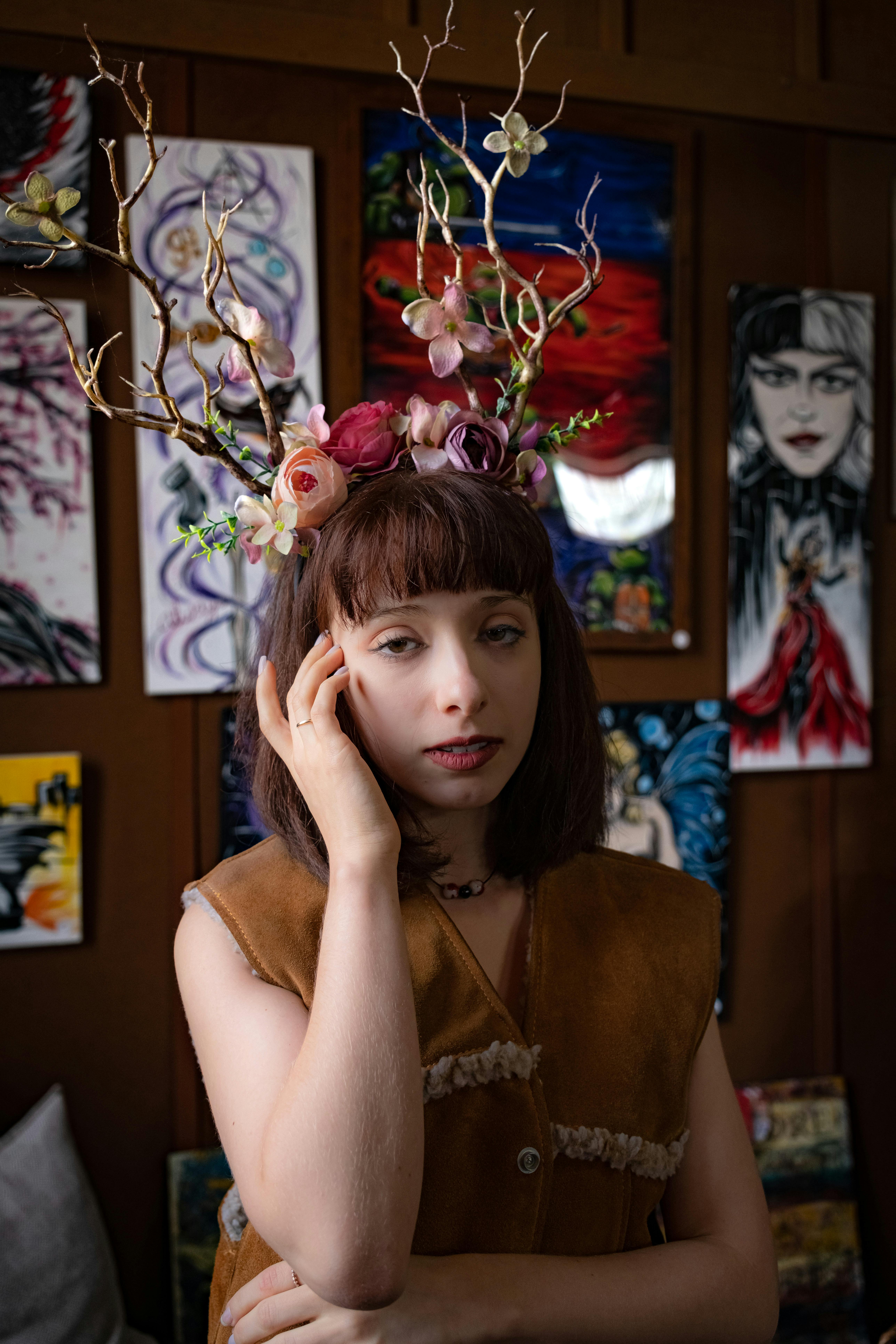 a woman wearing a deer head headdress in front of a painting