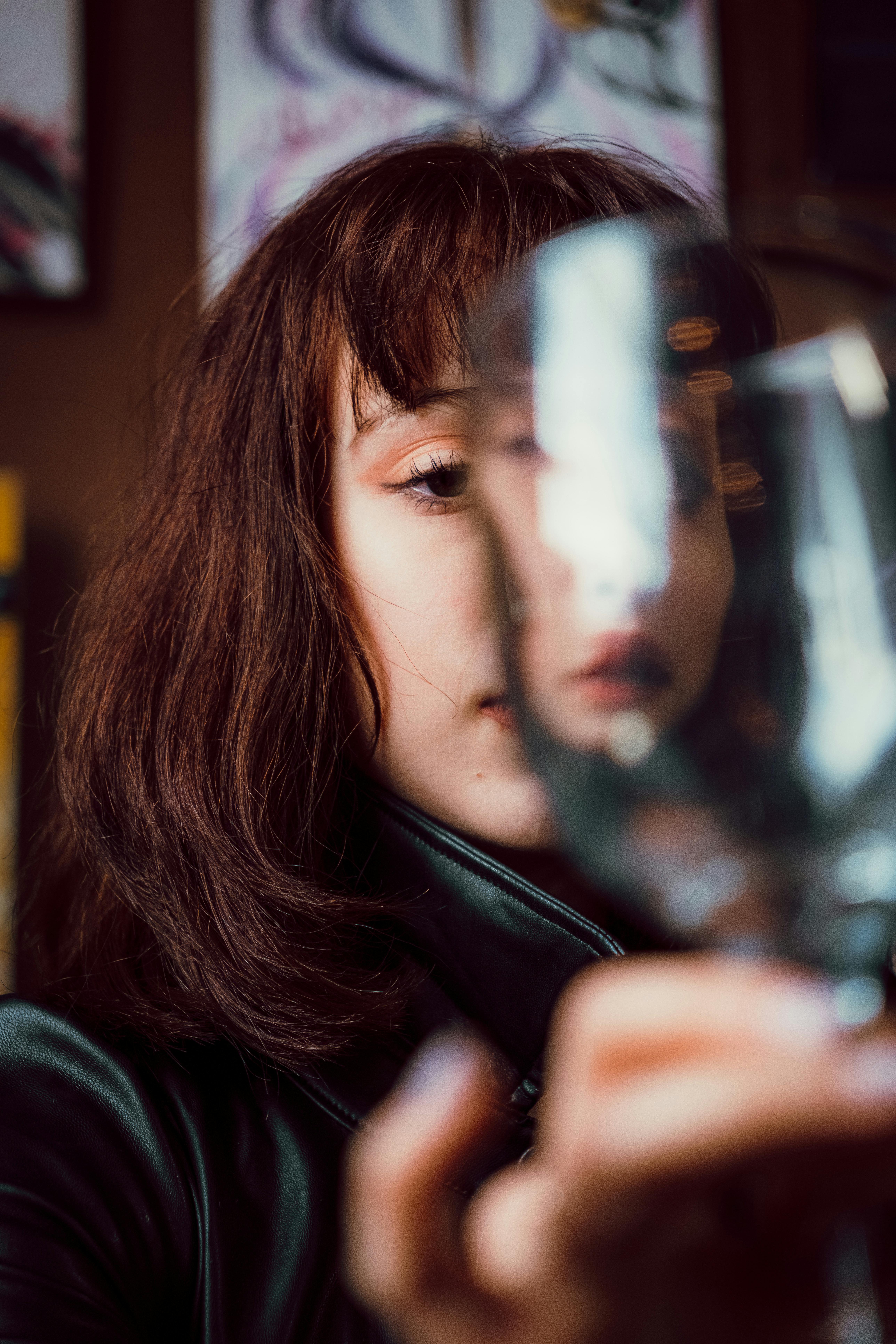 a woman holding a wine glass in front of her face