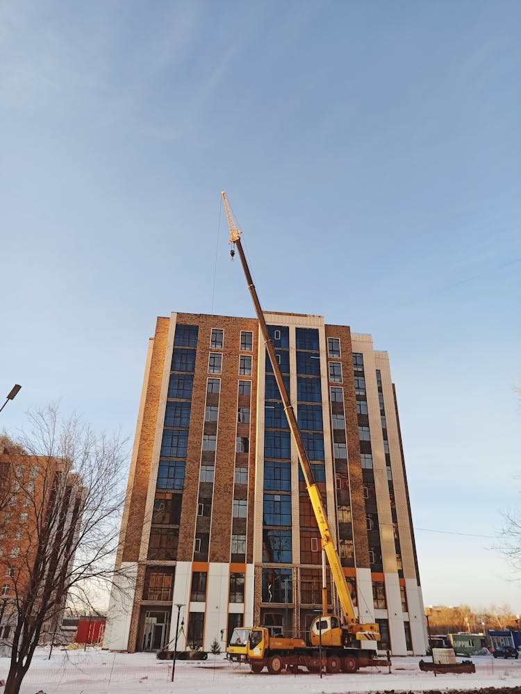 Crane Over Building In Town In Winter