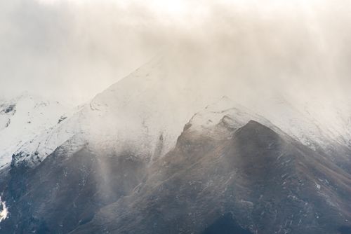 Free Majestic snow-covered mountains covered in mist with a calm and serene atmosphere. Stock Photo
