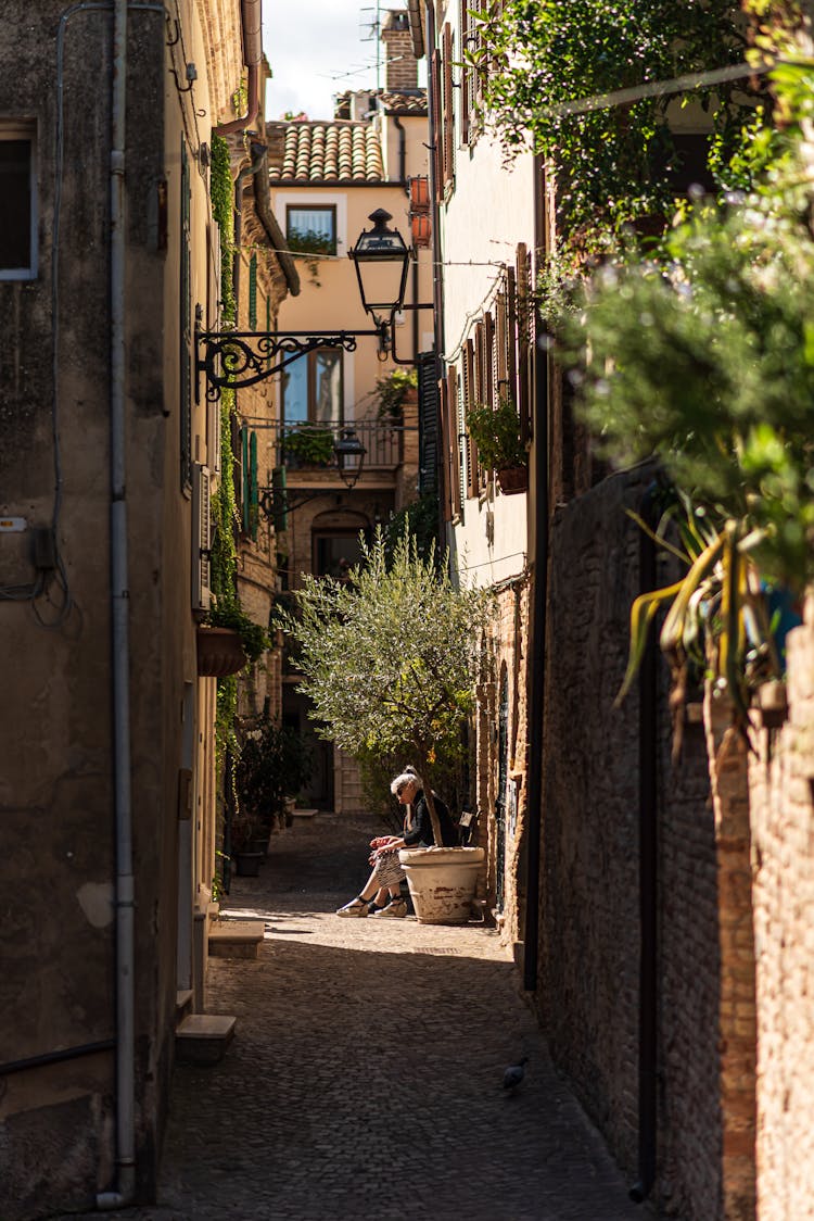 People In Alley Between Buildings