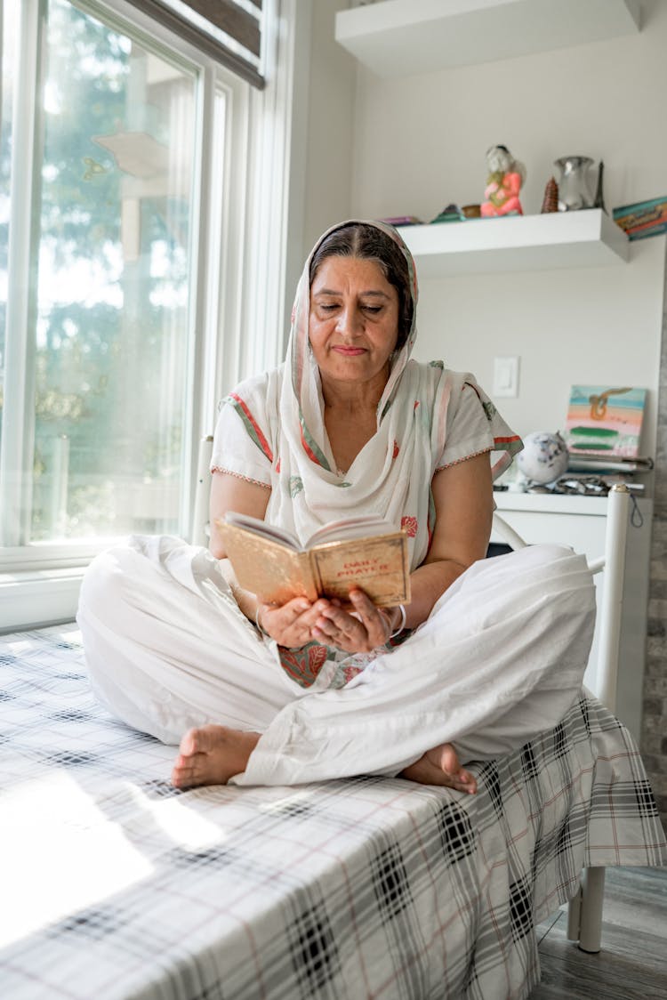 Woman Sitting On Table And Reading Book