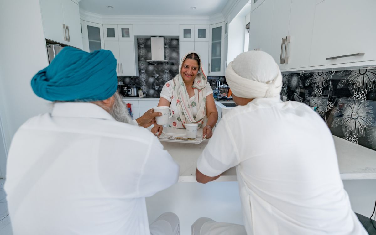 Family members engaging in conversation at a modern kitchen counter indoors.