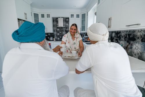 Free Family members engaging in conversation at a modern kitchen counter indoors. Stock Photo