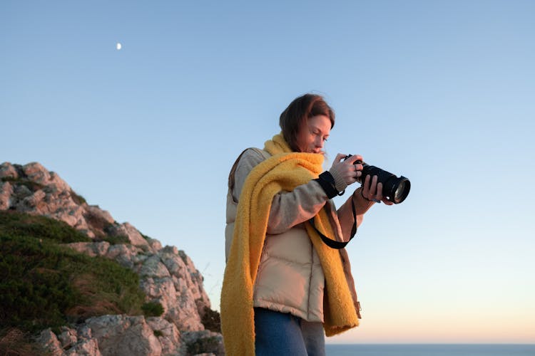 A Woman Using A Digital Camera In Taking Picture