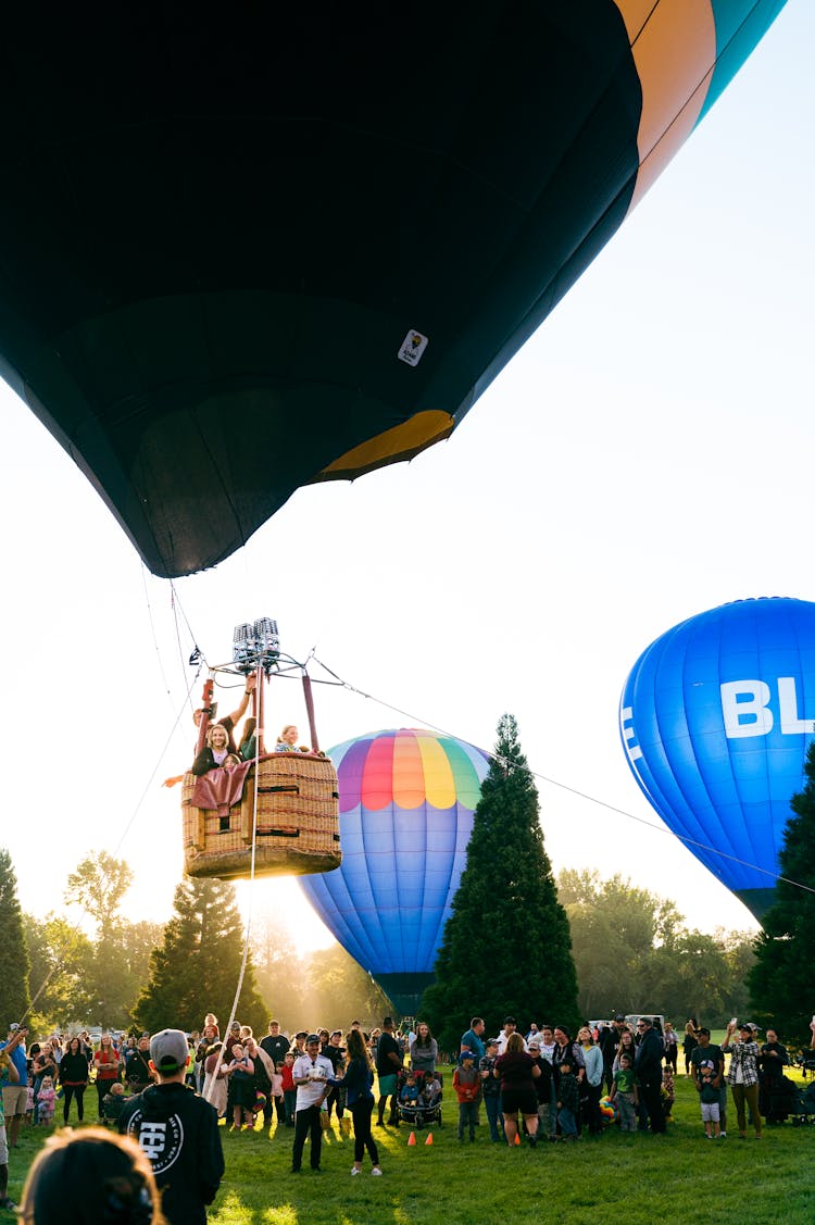 People Standing Around Balloons In Park