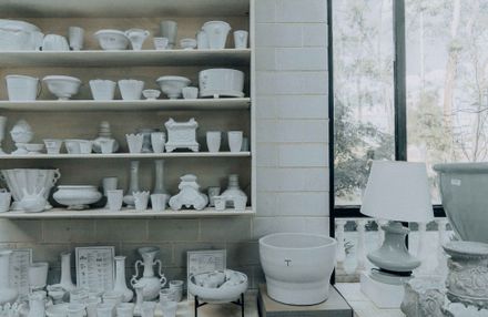Handmade ceramic cups and bowls on workshop shelves — photo by Amar Preciado on Pexels