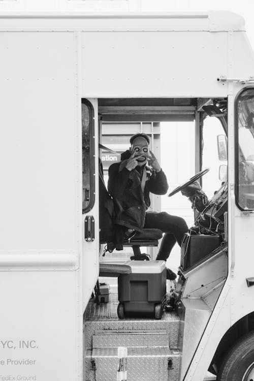 Free Man in Scary Mask Sitting at Steering Wheel in Bus Stock Photo