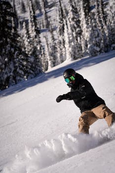 Experience the excitement of snowboarding down a snowy mountain slope in winter.