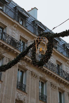 Elegant Parisian architecture adorned with festive Christmas decorations and garlands.