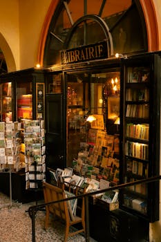 Cozy vintage bookstore in Paris showcasing books and postcards under warm lighting.