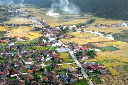 Free Aerial photo showcasing a picturesque countryside village with fields and mountains. Stock Photo