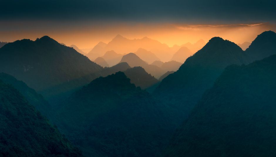 A captivating view of misty mountain ranges during sunset, showcasing nature's tranquility.