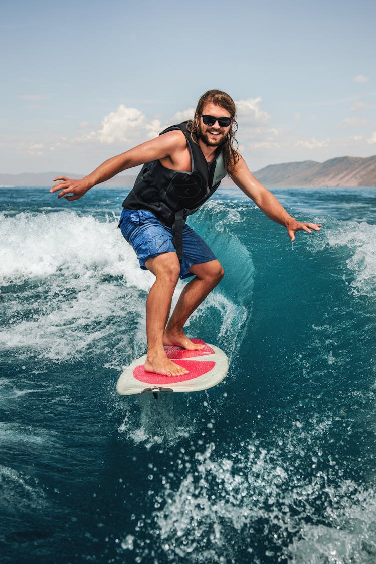 Smiling Man Surfing On Wave In Ocean