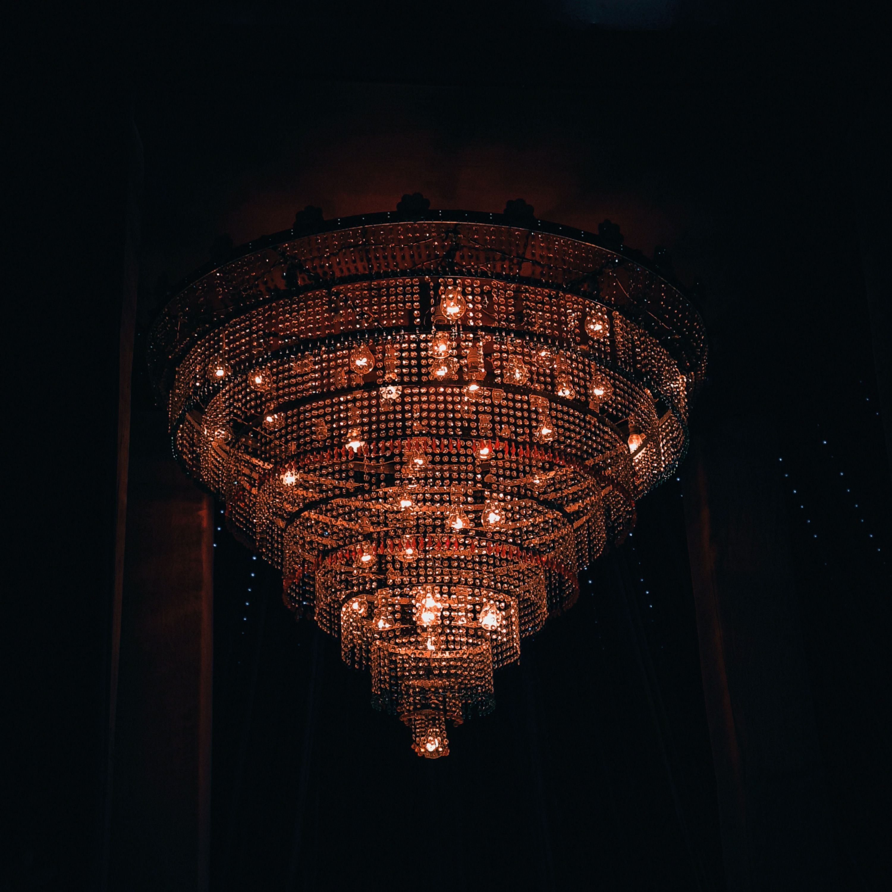 Stunning vintage chandelier glowing warmly in a dark setting, perfect for luxurious ambiance.