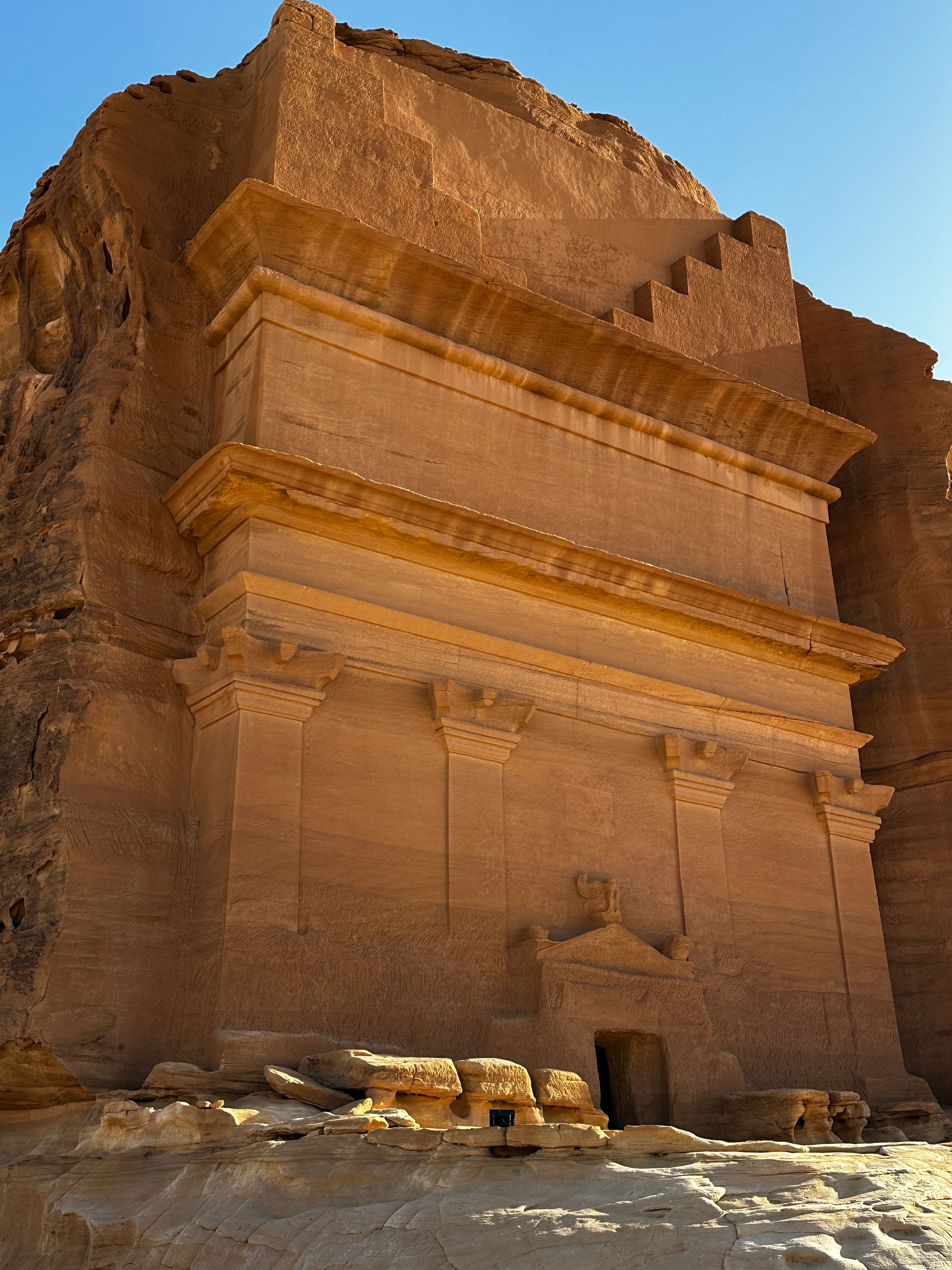 Explore the intricate facade of an ancient rock-cut monument in the desert.