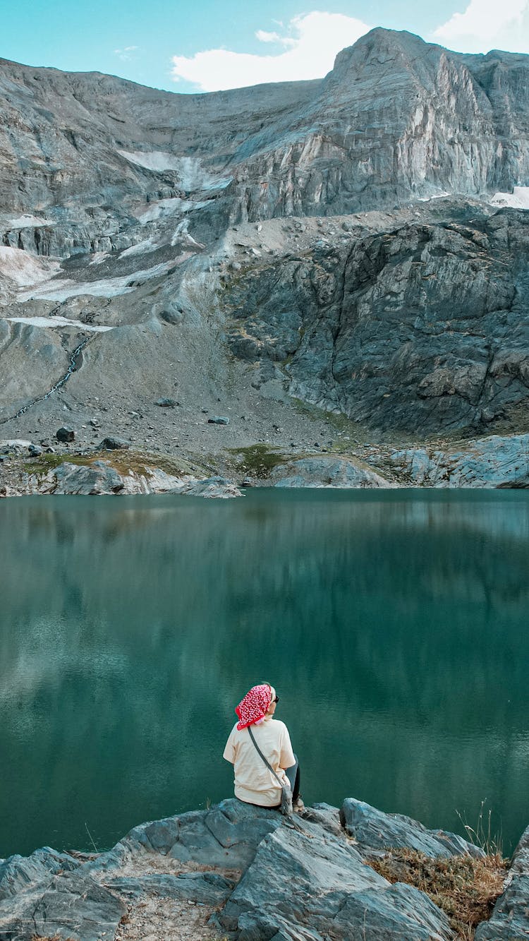 Woman Relaxing By Lake In Mountains 