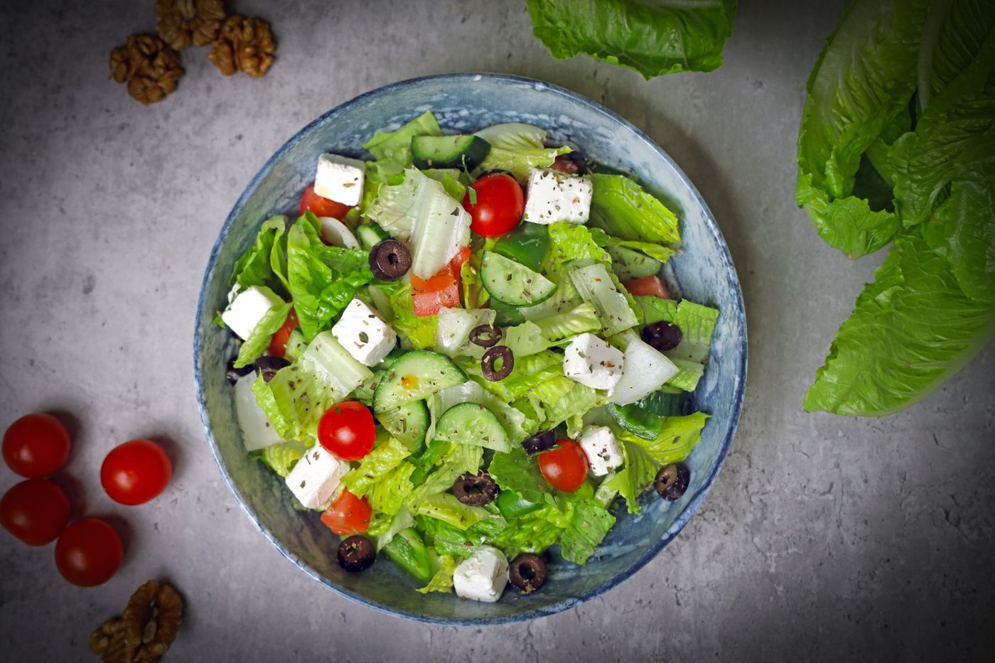 Top-down view of a vibrant Greek salad with fresh vegetables and feta cheese.